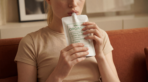 A woman drinking a SaladPower pouch at home